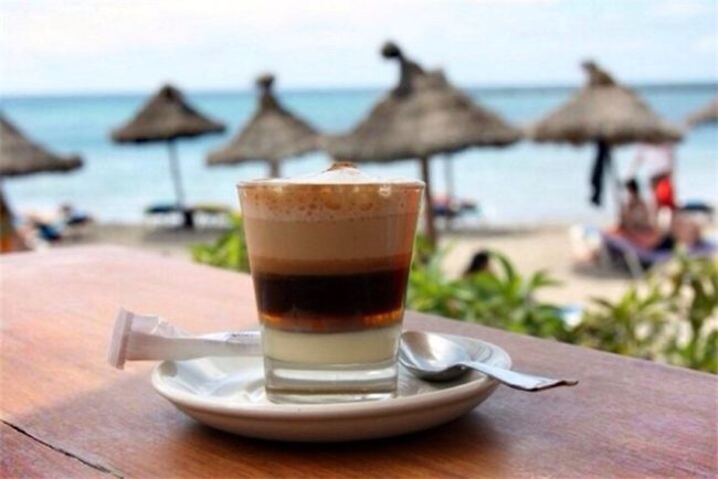 Кофейный напиток в бокале на пляже