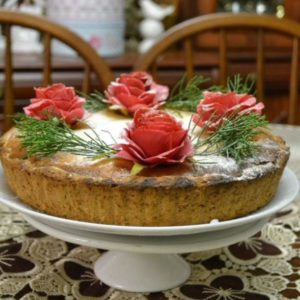 Украшенный розами пирог из творога на тарелке