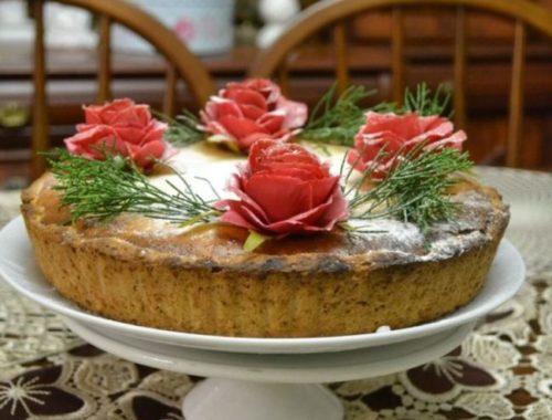Украшенный розами пирог из творога на тарелке